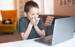 ילד מסתכל בבהלה על מסך מחשב